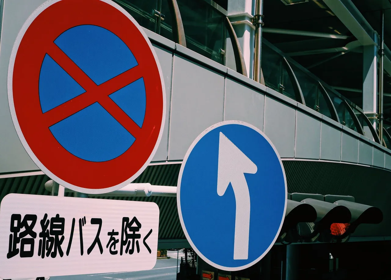 Close-up street signs indicating direction and prohibition in Tokyo, Japan.