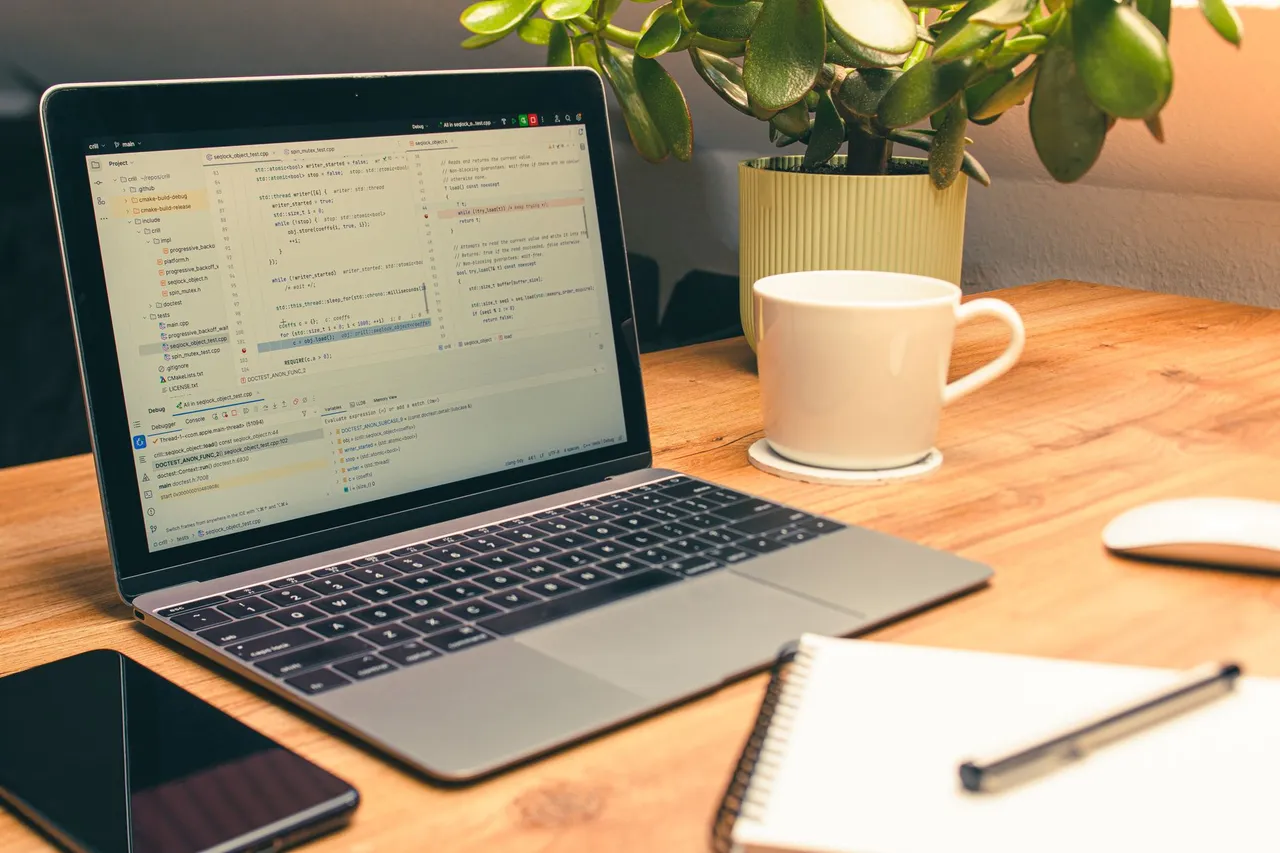 Cozy home office setup featuring a laptop, coffee, and a green plant for productivity.