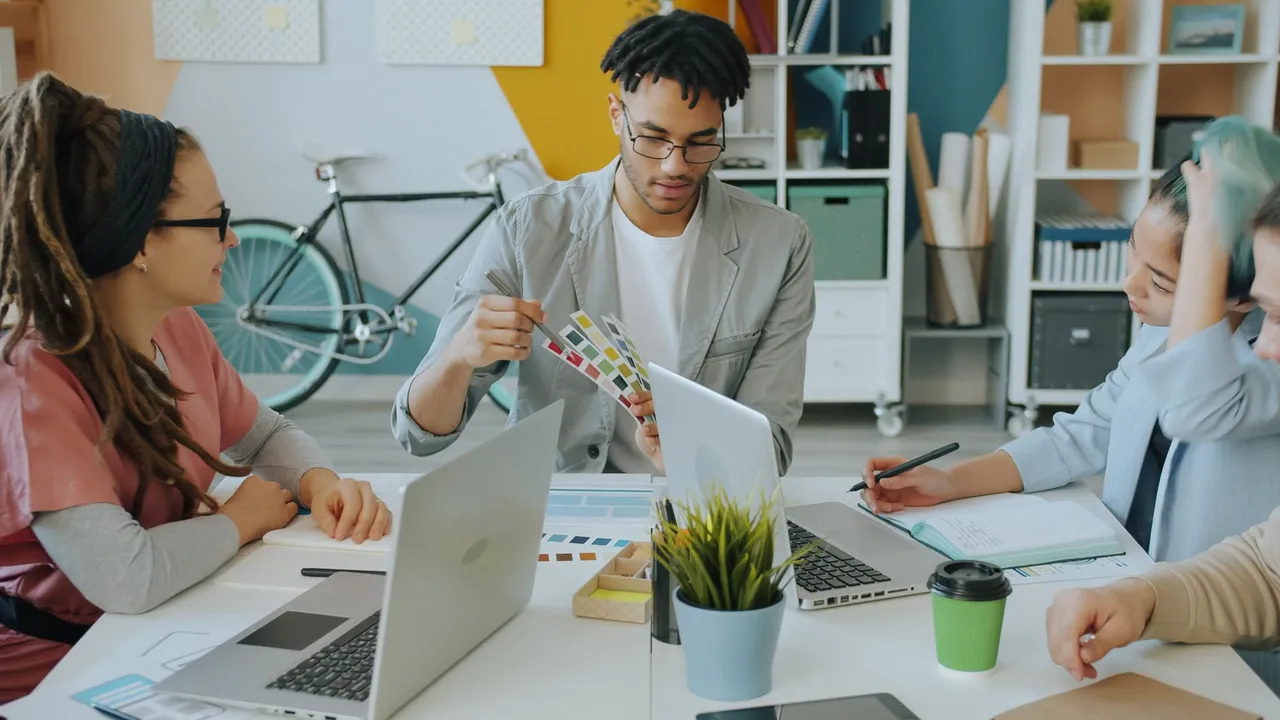 Diverse creative team discussing color samples during a meeting in a modern office.