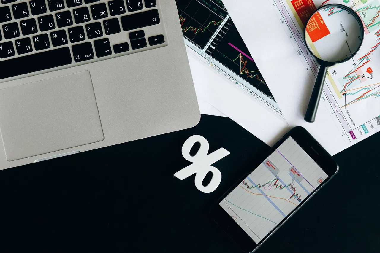 A top-down view of analytical data sheets and a laptop, ideal for business analysis themes.