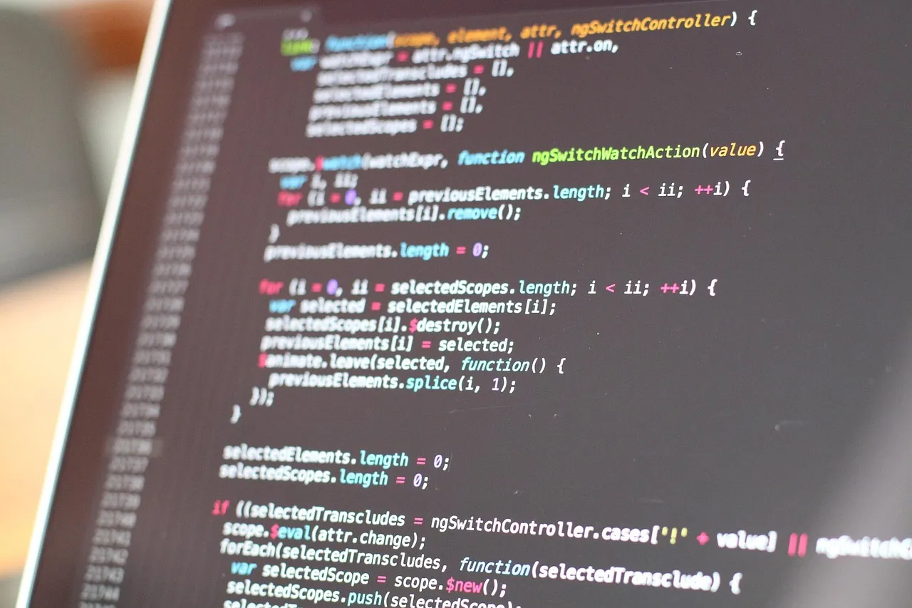 Close-up of colorful programming code on a blurred computer monitor.
